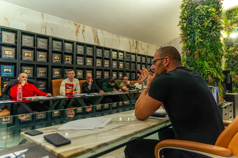Sessione di consulenza Theory attorno al tavolo, davanti alla wall of fame